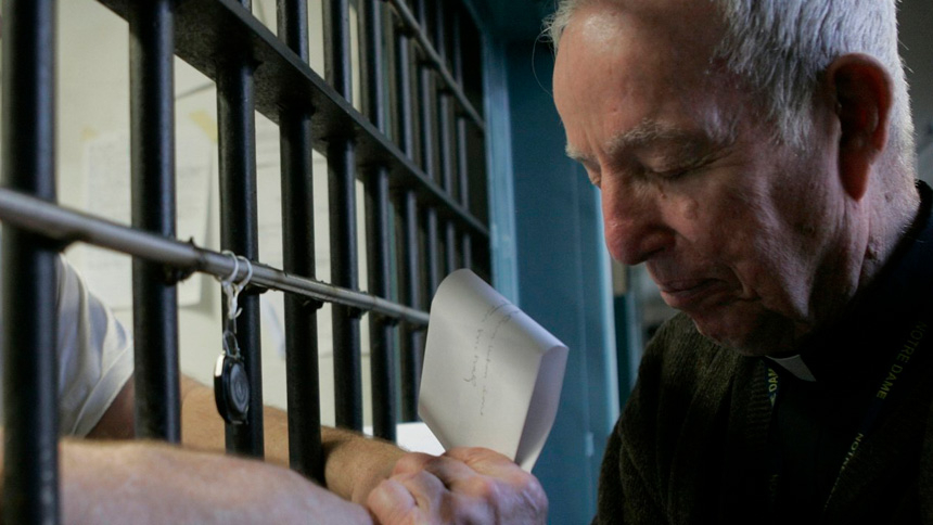 A priest prays with a death-row inmate in 2008 at Indiana State Prison in Michigan City, Ind. (CNS photo/Tim Hunt, Northwest Indiana Catholic)