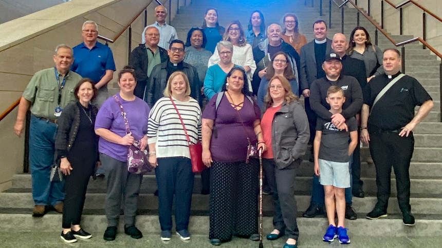 The Eucharistic Congress committee stops for a photo at the Raleigh Convention Center during a planning meeting.