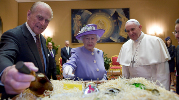 Britain's Prince Philip offers a gift to Pope Francis during a meeting with Queen Elizabeth II at the Vatican April 3, 2014. Prince Philip died April 9, 2021, at age 99; Queen Elizabeth died Sept. 8, 2022, at age 96. (CNS photo/Maria Grazia Picciarella, pool)