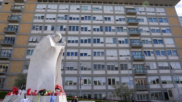 Votive candles, flowers and messages for Pope Francis are placed at the base of a statue of St. John Paul II outside Rome’s Gemelli hospital Feb. 27, 2025, while Pope Francis receives treatment for double pneumonia. (CNS photo/Lola Gomez)