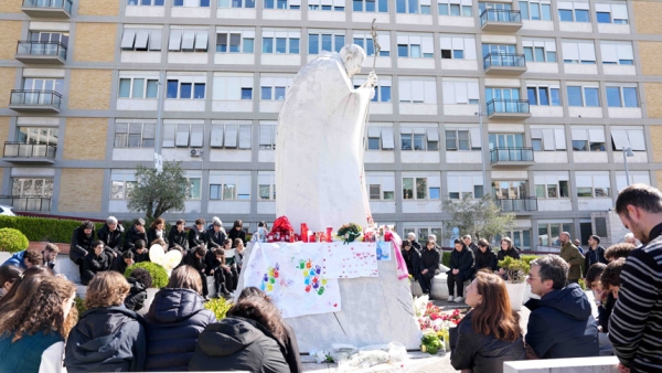 Young people and members of the House of Mary, groups associated with the Pontifical Academy of the Immaculate Conception, and others pray around a statue of St. John Paul II outside Rome’s Gemelli hospital March 2, 2025. Pope Francis is receiving treatment there for double pneumonia. (CNS photo/Lola Gomez)